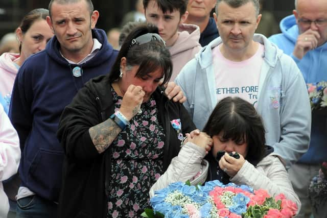 Parents Caroline Curry, wearing black jacket, Lisa Rutherford, with flowers, and Mark Rutherford, standing behind Lisa, at Tuesday's tribute to Chloe and Liam.